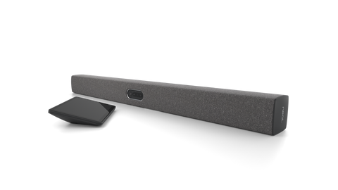 An angled view of the Neat Bar Pro, a video bar for video conferencing. It is dark grey in colour. Next to it is a tablet-style touchscreen, the Neat Pad.